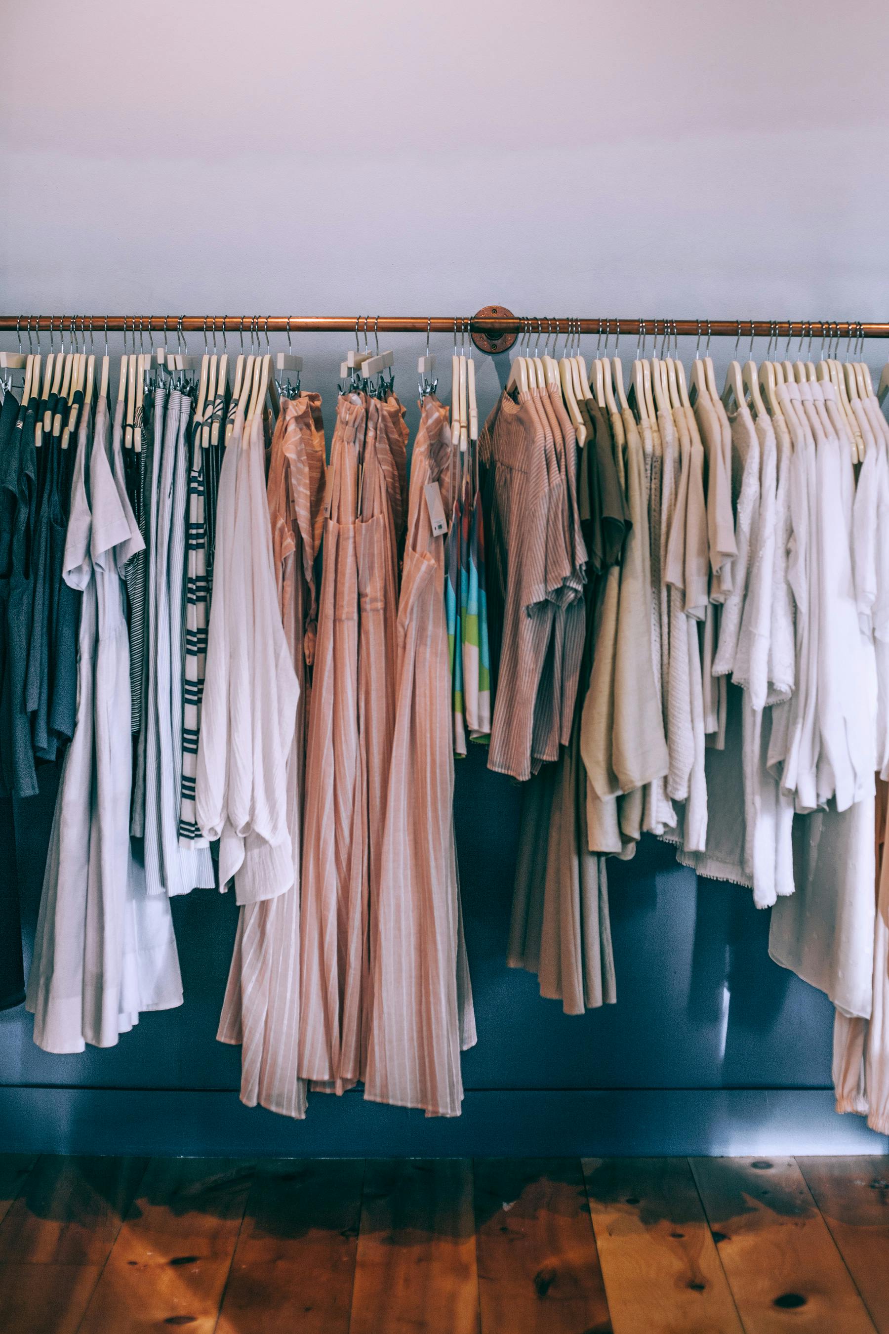 Warm-toned clothing rack with neatly arranged garments in a boutique.