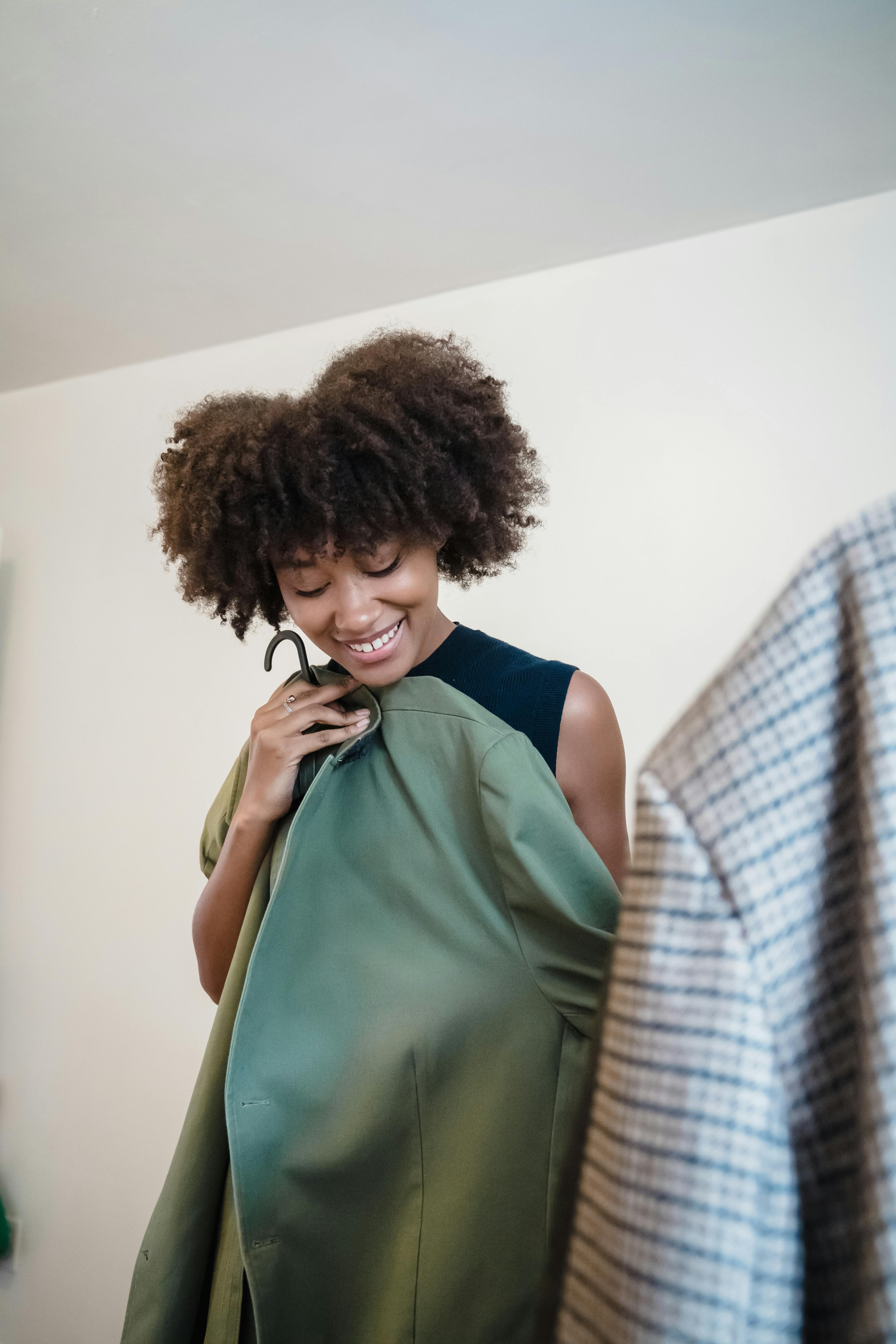 Smiling woman holding a garment she has just selected.